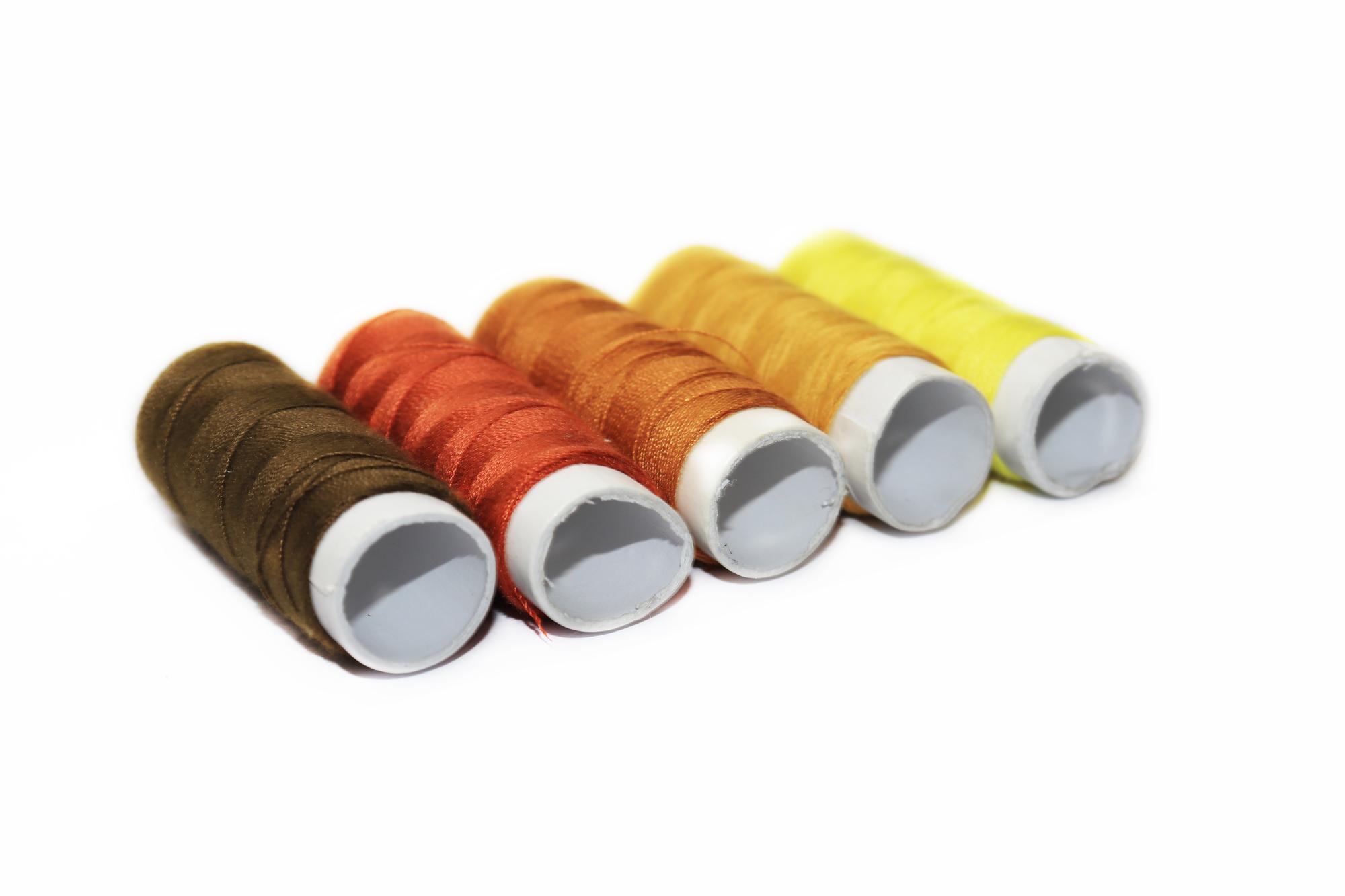 Stack of thread spools and embroidered swatches